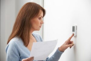 Woman Adjusting smart Thermostat